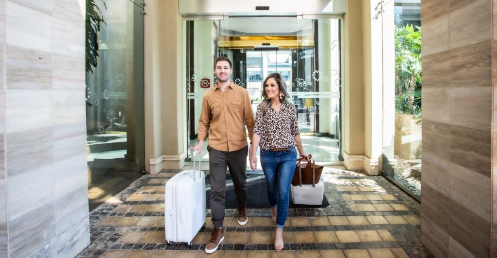 Couple walking into Southern Sun Silverstar hotel with luggage